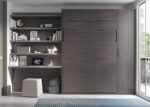 Bedroom with a vertical folding double bed and study area.